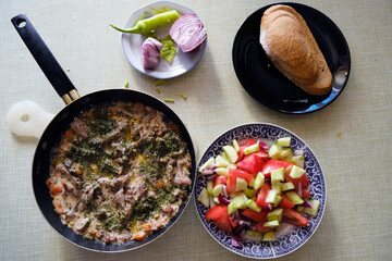 Fresh mushroom saute with bacon and vegetables, decorated with salad on a kitchen table, top view 