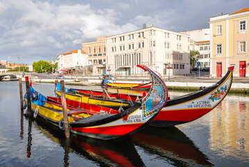 Fototapeta na wymiar Colorful Moliceiro boat rides in Aveiro are popular with tourists to enjoy views of the charming canals.