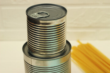 Cans, buckwheat, pasta and noodles on a green background with space for text. Deficient food during quarantine. Canned food.