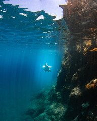 Beautiful girl swimming and freediving in the blue crystal clear mediterranean sea