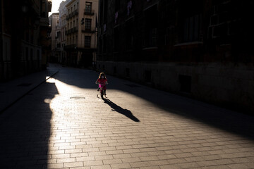 Niña en bicicleta en calle solitaria de Valencia