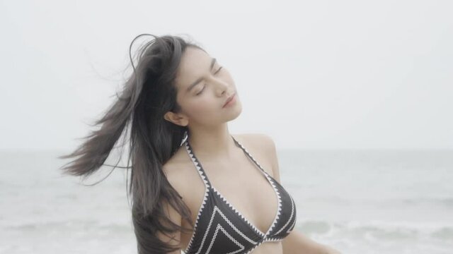 Beautiful tanned young asian woman in bikini playful at the beach, girl sexy happy and smiling on summer travel in vacation, woman relax wearing swimwear or swimsuit fashion in tropical.