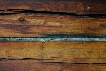 Wooden background. Logs on the wall of the log frame as a background. Wooden wall assembled of logs. Wood construction