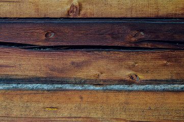 Wooden background. Logs on the wall of the log frame as a background. Wooden wall assembled of logs. Wood construction