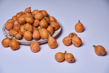 Medlars in a wooden plate and on the table