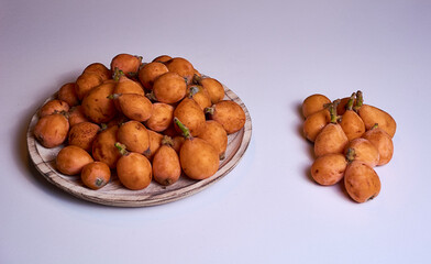 Medlars in a wooden plate and on the table