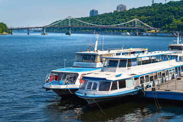 Fototapeta na wymiar Two river pleasure boats moored to the pier for landing tourists. Navigation nae Dnieper.