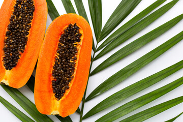 Sweet ripe papaya on tropical palm leaves.