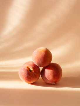 Fresh peaches on a pastel background with shadows