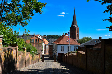 Fototapeta na wymiar Gasse in Plön mit Kirchturm, Schleswig-Holstein