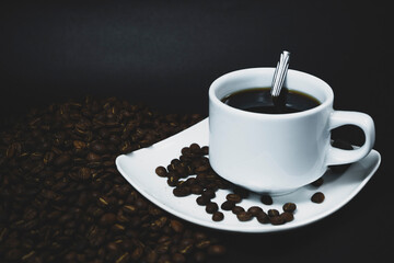 Coffee cup and coffee beans on black background