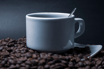 Coffee cup and coffee beans on black background