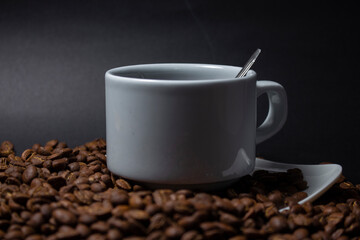 Coffee cup and coffee beans on black background
