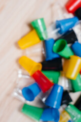 A large pile of multicolored plastic cups scattered on the floor with free space, out of focus. Pollution of the environment by human waste