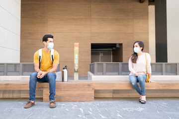 Obraz na płótnie Canvas Couple Maintaining Social Distance While Sitting Outdoors
