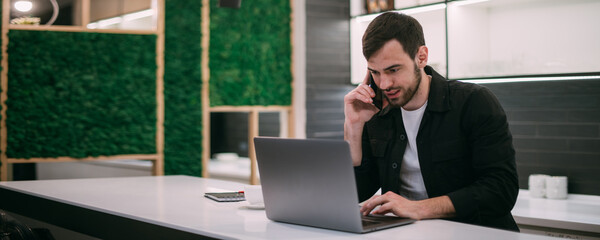 A man works on a laptop in an office or coworking