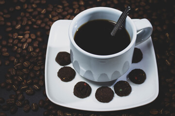 Coffee cup and coffee beans on black background