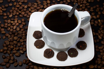 Coffee cup and coffee beans on black background