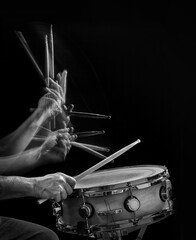 Drummer's hands  and drumsticks in motion  hitting a snare drum