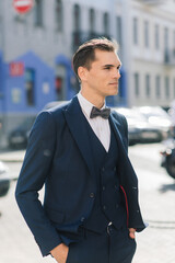 Portrait of an attractive young businessman in urban background wearing suit and a tie.