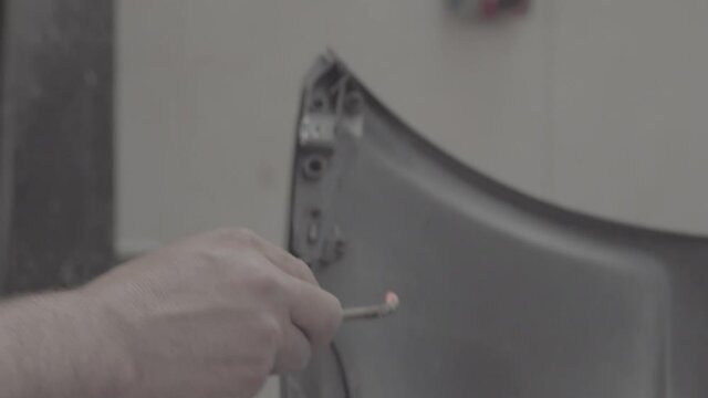 Mechanic working on the car door. Delivered in ambiance sound,  100mbps S-Log3. Ready for color grade. Ungraded 