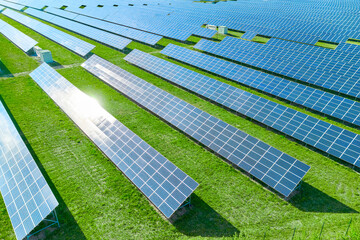 Solar panels producing green renewable energy. Solar power station in the field with green grass. - obrazy, fototapety, plakaty