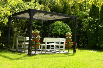 A close up on a decorative, well maintained outside shack with white wooden benches, roof made out...