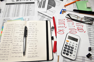Top view of office employee's desk - work with financial reports, analysis and accounting, tables and graphs, various office items for bookkeeping