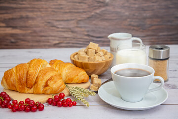 Breakfast in the morning, black coffee cup with bread, Croissant and fruit on the wooden table.