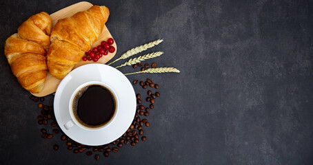 Breakfast in the morning with black coffee cup with bread with Croissant and fruit on the black background.