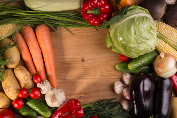 Assortment of fresh raw vegetables on a wooden table. Healthy food Top view background with empty space.
