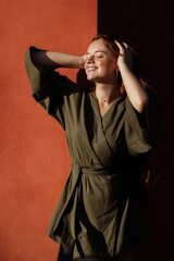 red-haired girl with freckles in green kimono in the sun