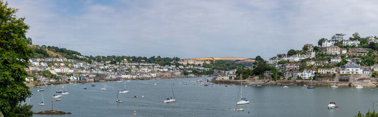 Wide panoramic shot of the River Dart with Kingswear in the background. Boats on the river Dart in Dartmouth, South Devon. The town of Kingswear can be seen in the background.