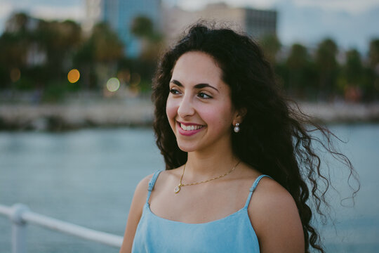 Portrait of young smiling woman having fun on urban jetty