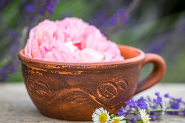 Selective focus old vintage ceramic cup of tea with flowers. Old rustic wooden table ware.