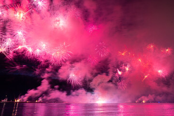 Colorful fireworks reflect from water, beautiful scenery