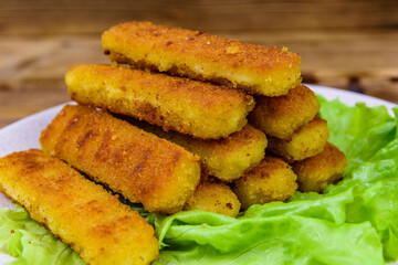 Baked fish sticks and lettuce leaves in a plate