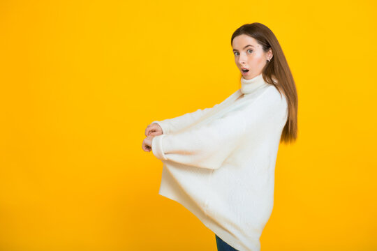 Slim woman in oversized sweater on yellow background. Weight loss