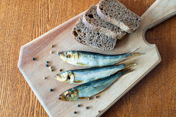 Still life with fish and bread on a wooden cutting board