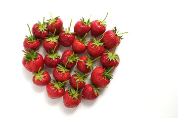 Fresh big strawberries with long stems in heart shaped form 