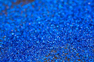 Beautiful Christmas light background. Abstract glitter bokeh and scattered sparkles in gold, on black