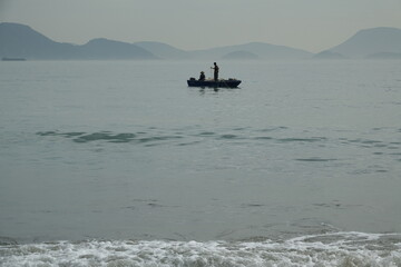 Naklejka premium Silhouette of people on fishing boat in the ocean