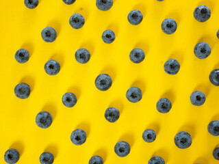 Scattered blueberries on a yellow background