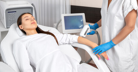 Elos epilation hair removal procedure on a woman’s body. Beautician doing laser rejuvenation on the hand in a beauty salon. Removing unwanted body hair. Hardware ipl cosmetology