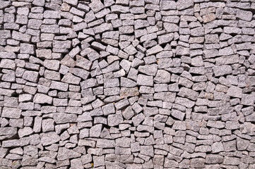 Close-up of the surface of an effective and very durable fence made of split granite. Fence.