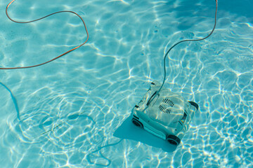Automatic robotic pool vacuum cleaner under water cleaning the floor.