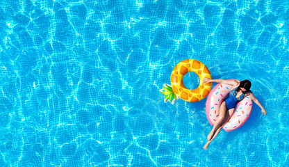 Pool water texture background with a woman on the inflatable water toys. Directly above. Top view...
