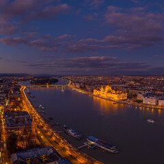 Aerial drone of lighted Hungarian Parliament by Danube river after Budapest sunset hour