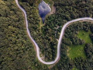 Top down aerial view on road with curves between the forest in nature on mountain range - Drone photo forest and asphalt road travel concept - Stara Planina Old Mountain travel destination in Serbia