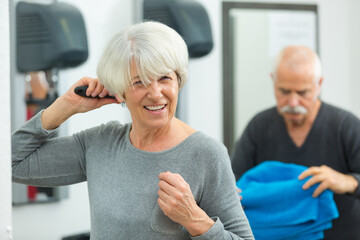 senior woman brushing her hair after fitness class